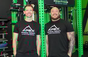 Eric Lea and Dr. Nathan Teter post in front of lime green equipment at Apex Physical Therapy and Sports Performance Milton, Georgia location 